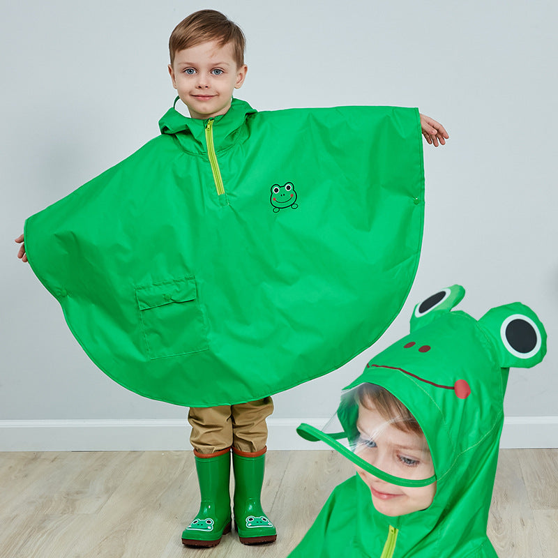 Barn med grønn regnponcho og matchende regnstøvler smiler inn i kameraet. Ponchoen har hette med morsomt dyredesign og gir full beskyttelse mot regn.