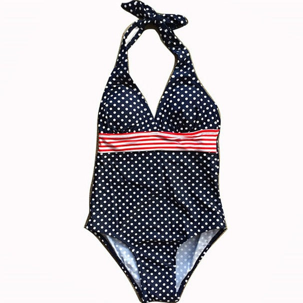 Mørkeblå badedrakt med hvite prikker og røde striper, designet for å gi et stilfullt og sporty look. Fremstilt av hurtigtørkende materiale med god strekkbarhet for optimal komfort. Perfekt til svømming, strandturer eller til å ha i bassenget.