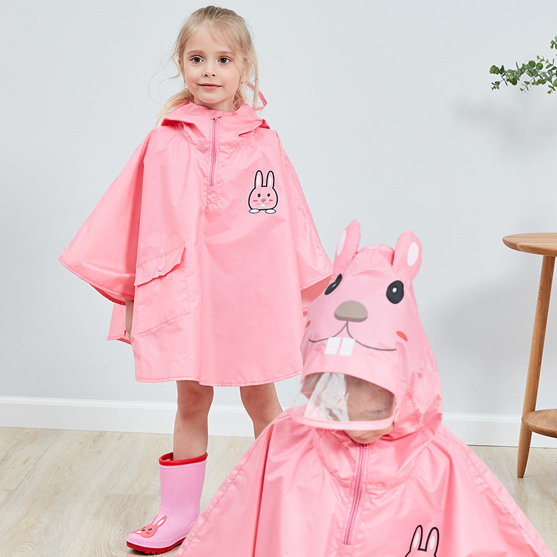 Barn med rosa regnponcho og matchende regnstøvler smiler inn i kameraet. Ponchoen har hette med morsomt dyredesign og gir full beskyttelse mot regn.
