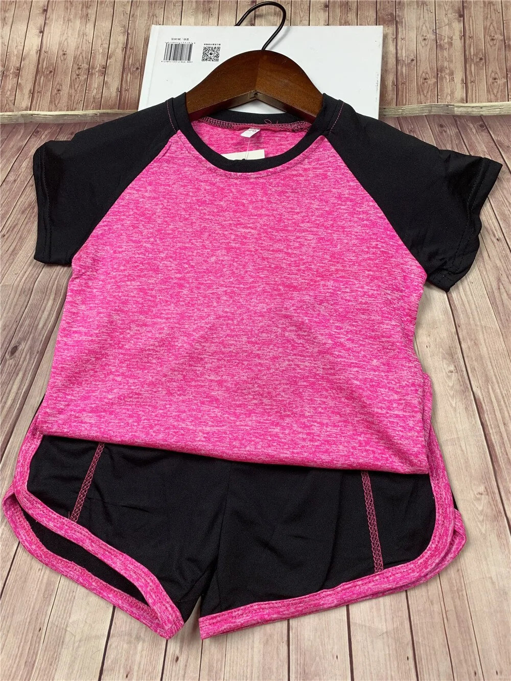Sporty treningsett for jenter i moderne design, laget av pustende materiale med fargerike detaljer. Settet inkluderer en komfortabel t-skjorte og fleksible leggings, perfekt for trening og aktiv fritid