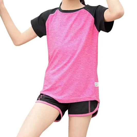 Sporty treningsett for jenter i moderne design, laget av pustende materiale med fargerike detaljer. Settet inkluderer en komfortabel t-skjorte og fleksible leggings, perfekt for trening og aktiv fritid.